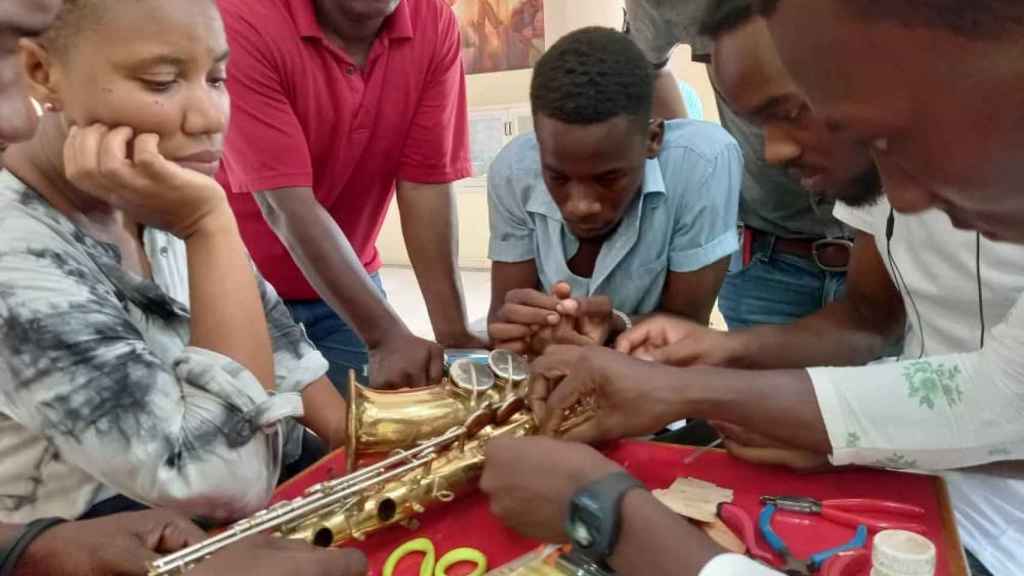 Jóvenes haitianos reparando sus instrumentos.