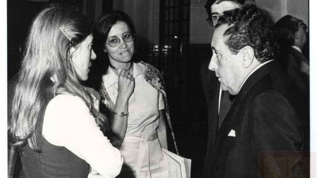 Las diputadas Carlota Bustelo, del Grupo Socialista, y Pilar Brabo, del Comunista, convesan con Pío Cabanillas, ministro de Cultura y Bienestar.