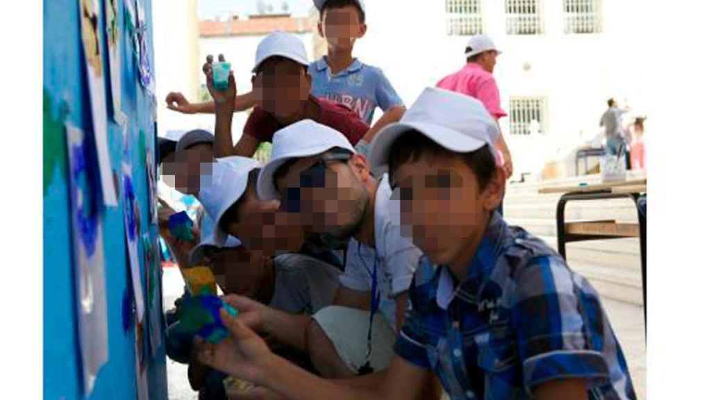 Menores marroquíes realizando  un mural junto a un tutor en el Centro Social Assadaka de Tánger.