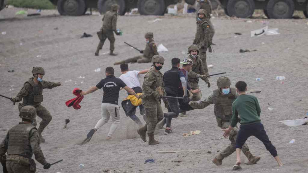 Militares españoles tratan de contener a inmigrantes marroquíes en la playa de El Tarajal el pasado mayo.