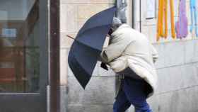 Un ciudadano se protege con su paraguas de las fuertes rachas de viento