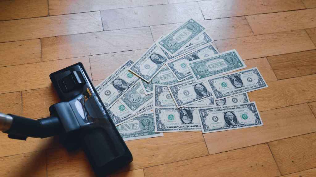 Un aspirador mientras aspira billetes de dólar.