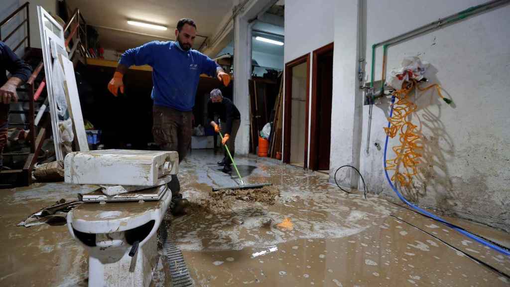 Vecinos continúan achicando agua tras las inundaciones registradas en Burlada, Navarra, este sábado.