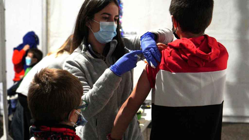 Un sanitario administra la vacuna contra la Covid a un niño.