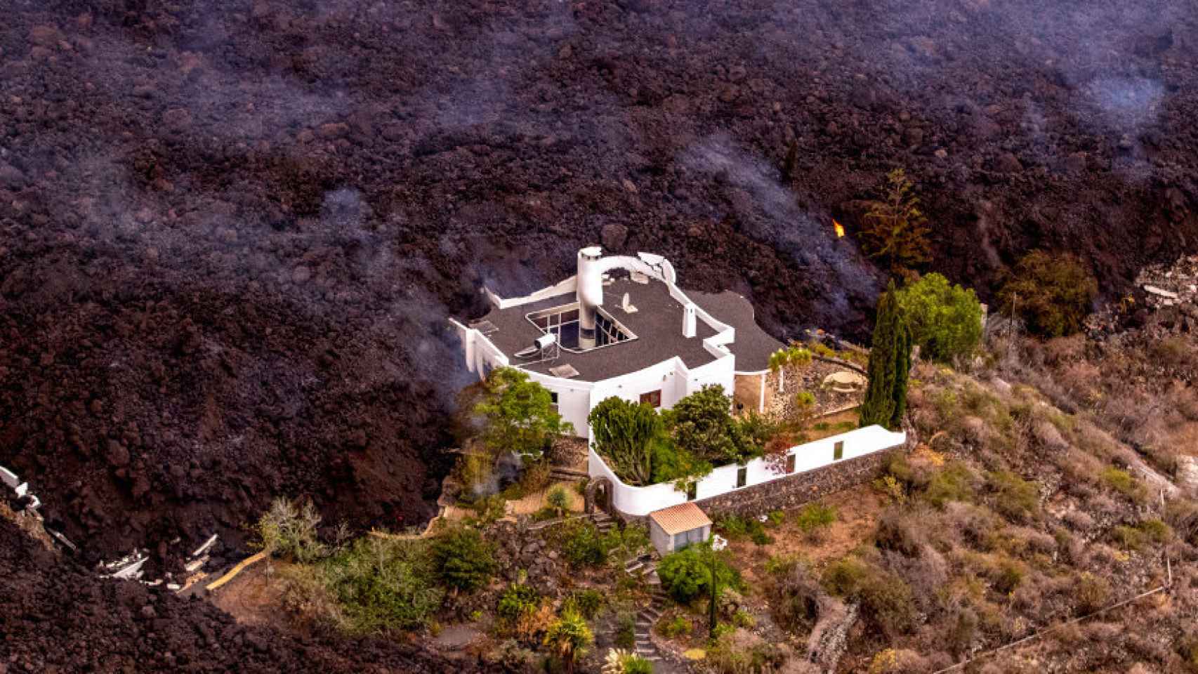 La lava rodea una vivienda en La Palma.