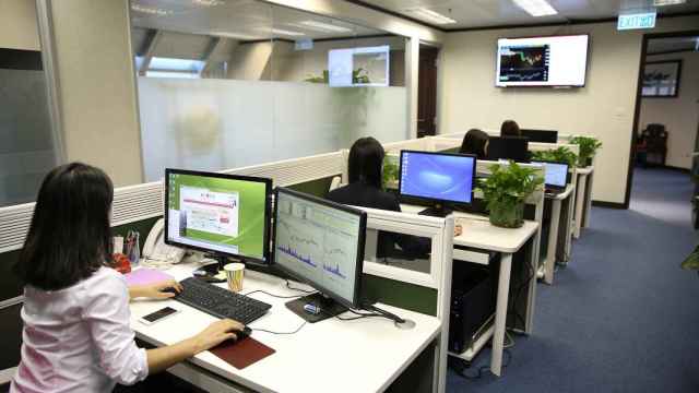 Una pequeña oficina con varios trabajadores en entornos digitales.