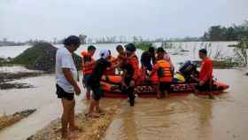 Personal de la guardia costera realizando una misión de rescate en una aldea afectada por las inundaciones.