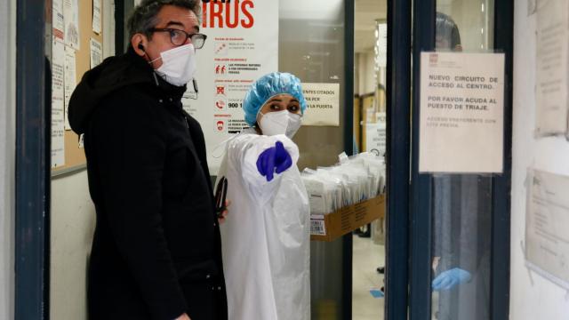 Una sanitaria y un paciente en la puerta de un centro de salud.