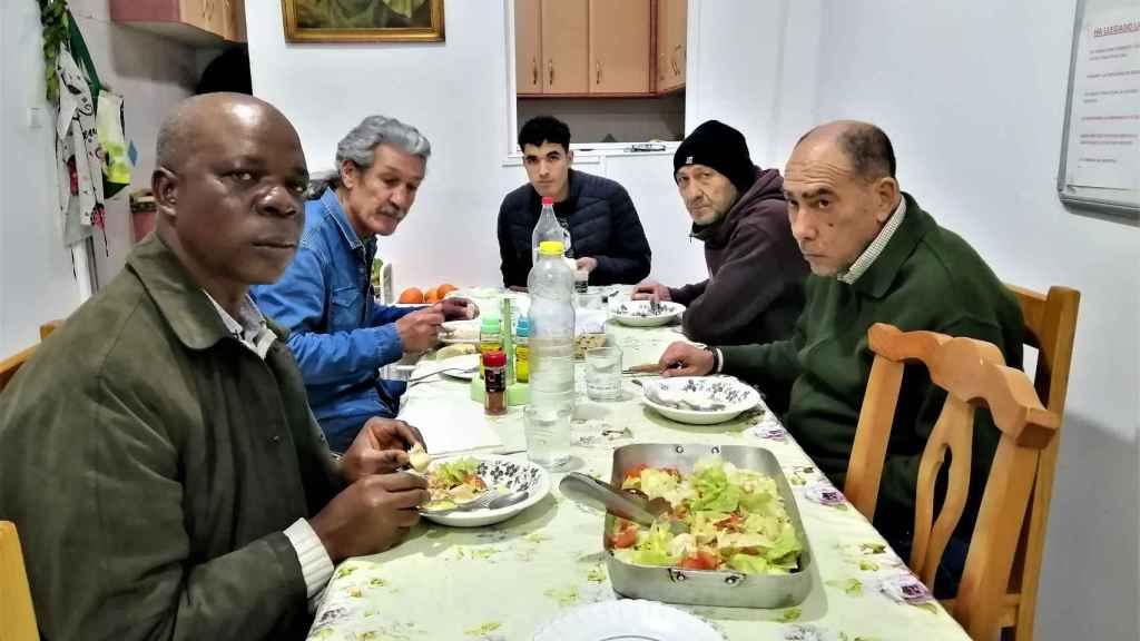 De izquierda a derecha, Monday, Antonio, Mohamed, Héctor y Javier, en una comida en la casa de acogida del número 112 de la calle Feria, en Sevilla.