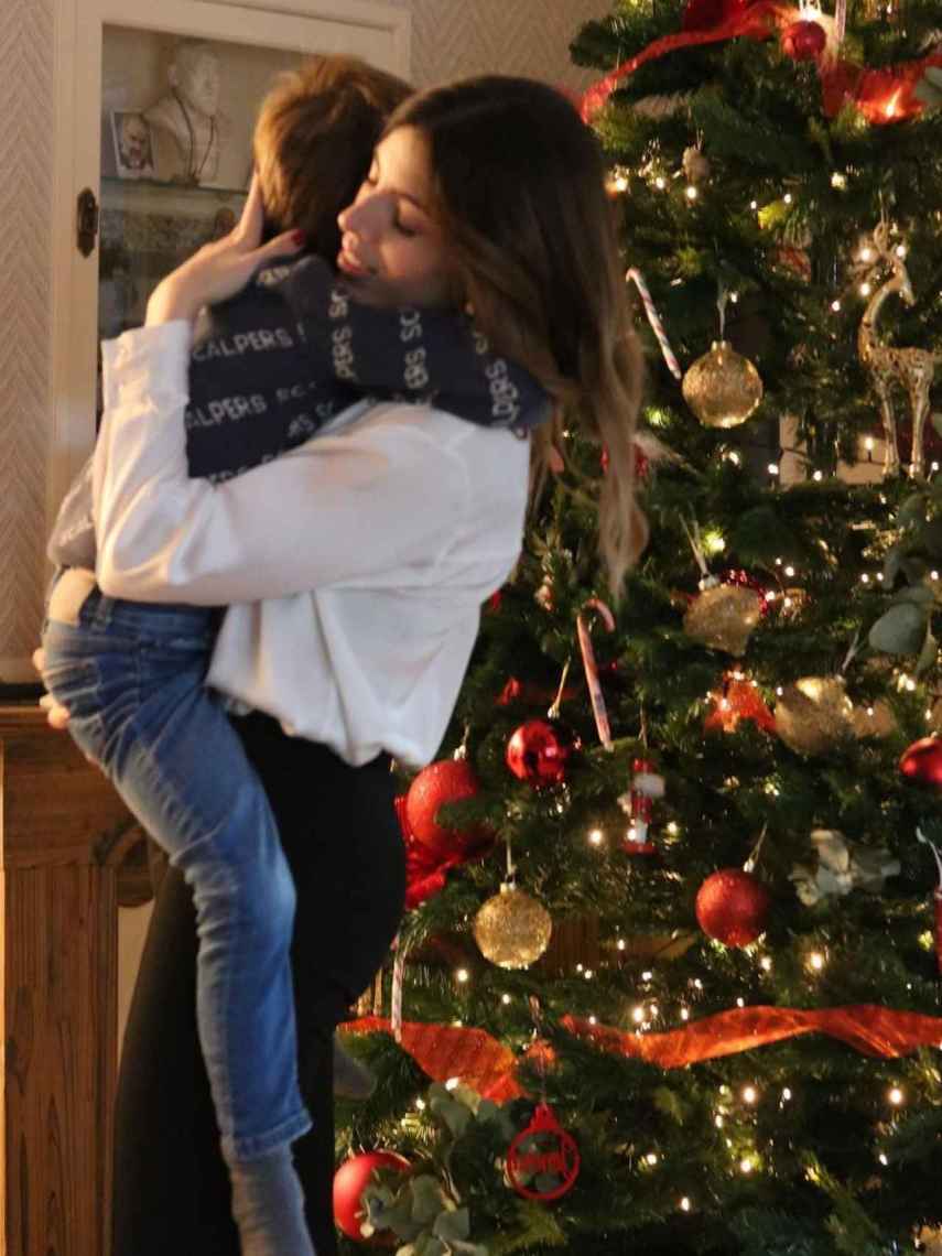 Lidia Bedman abraza a su hijo, Santiago, junto al árbol de Navidad de su hogar.