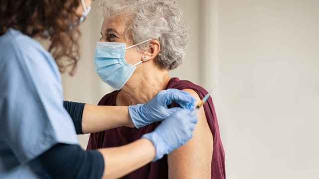 Una enfermera vacuna a una mujer mayor de 60 años.