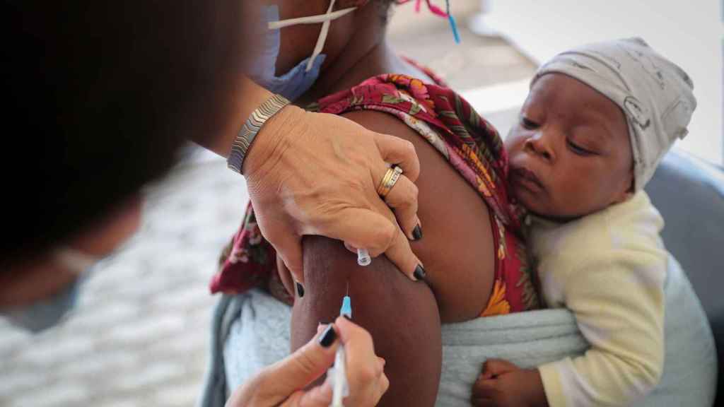 Un sanitario inocula una dosis de la vacuna contra la Covid a un niño. EP