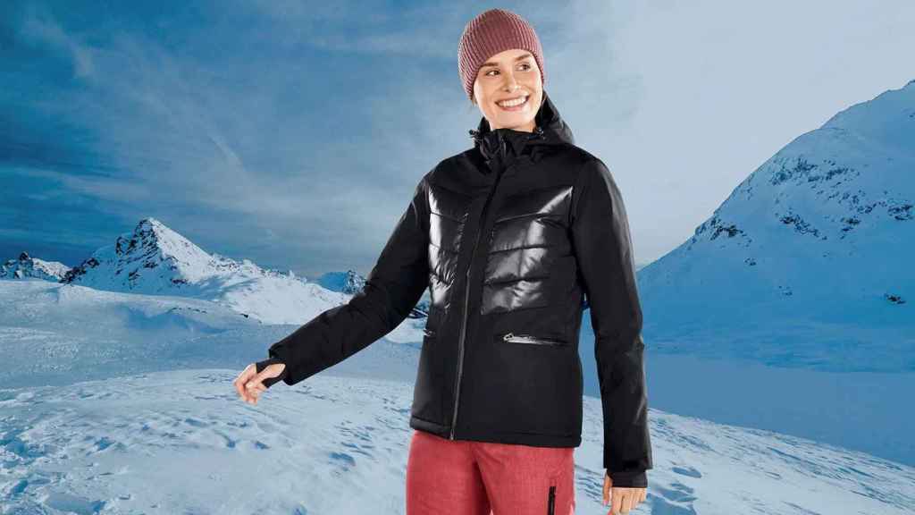 Mujer con ropa de esquí y gafas en la montaña de invierno de nieve.