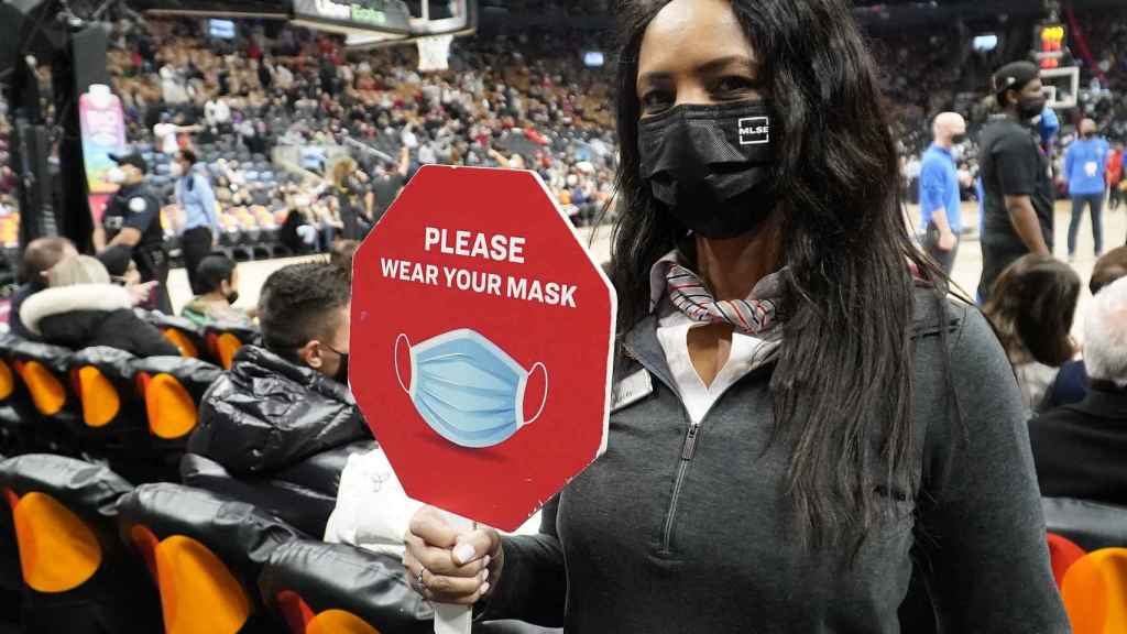 Una mujer pide portar la mascarilla en un partido de la NBA