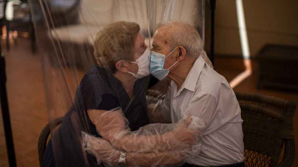 Dos ancianos se besan a través de un plástico en junio de 2020.
