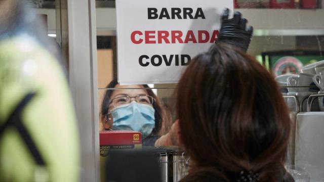 Un camarera coloca un cartel en su bar en Pamplona, Navarra.