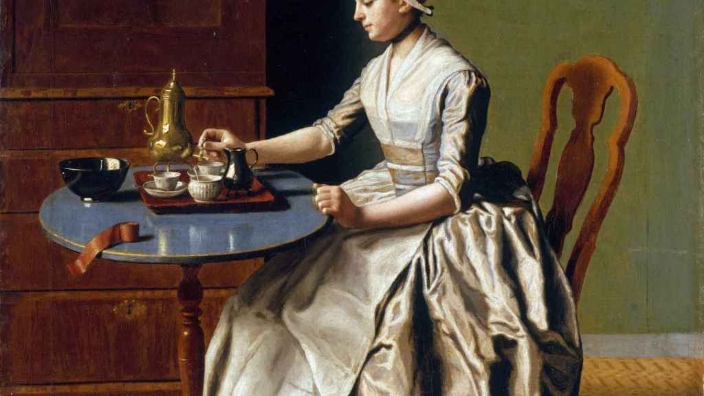 Retrato de una mujer tomando una taza de chocolate.
