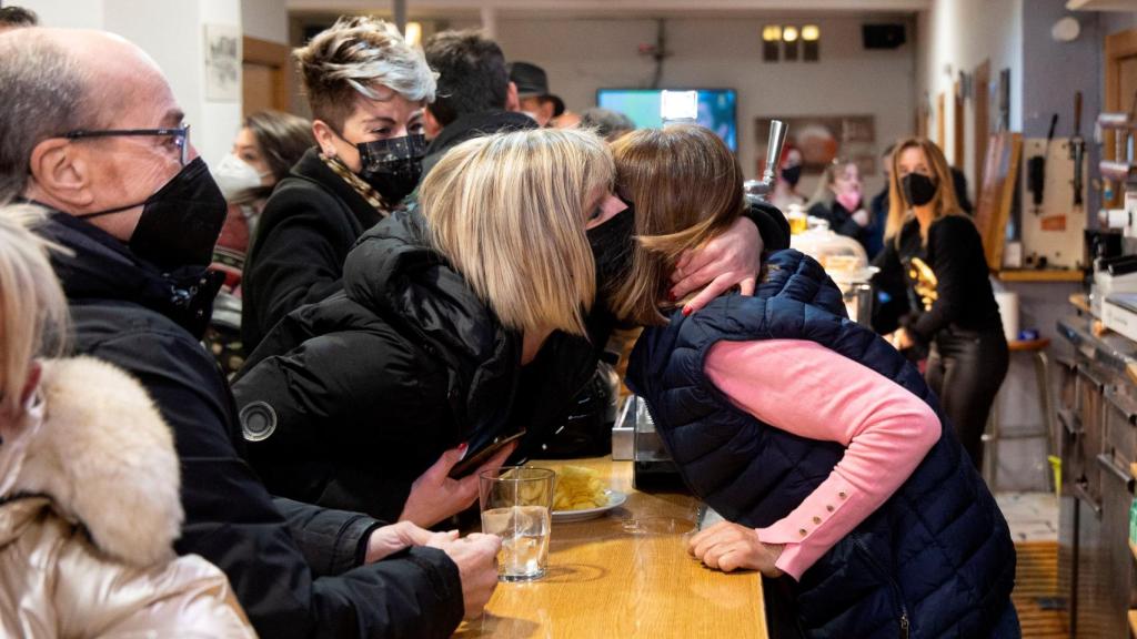 Yolanda Jiménez, at the bar counter, hugs another winning neighbor.