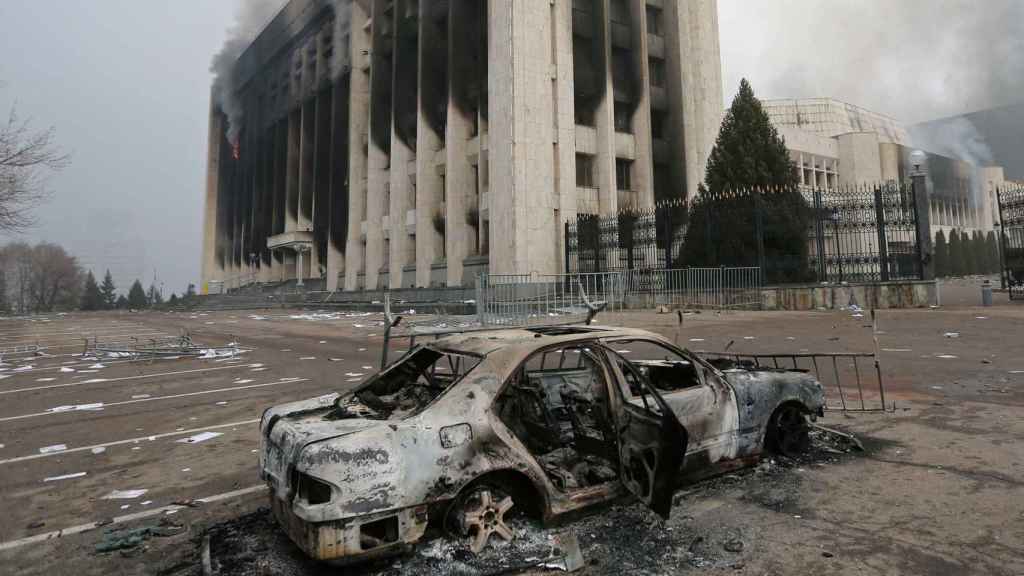 Un coche quemado frente a la oficina del alcalde que fue incendiada durante las protestas en Almaty.