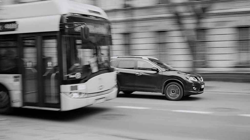 Un autobús y un coche en una imagen de archivo.