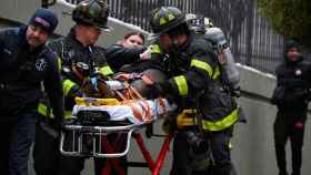 Los Bomberos de Nueva York auxiliando a un herido del incendio.