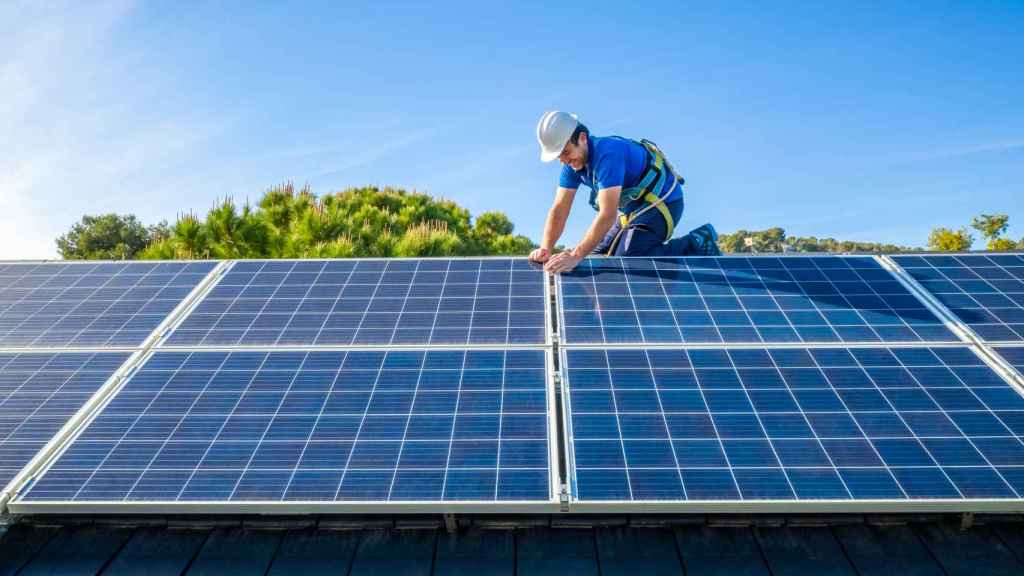 Un operario instala unas placas solares en un domicilio