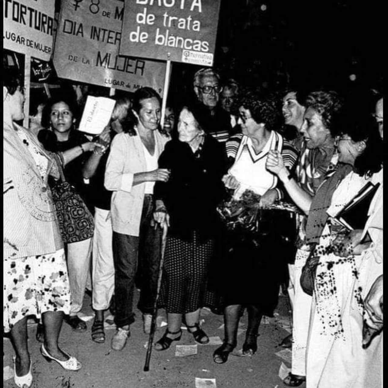 Alicia Moreau de Justo sujetando una pancarta. A su derecha se encuentra Elena Tchalidy.