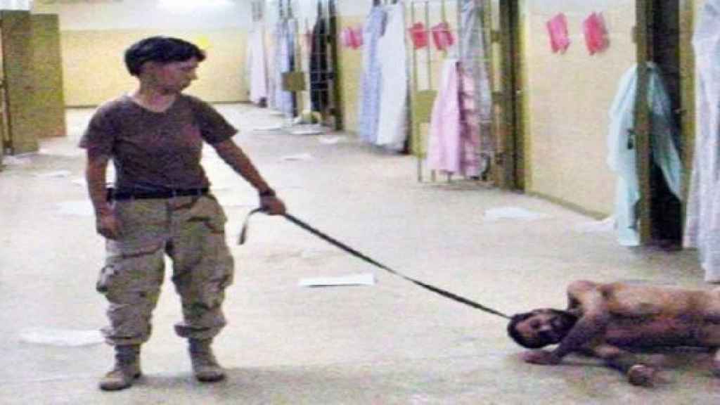 Un soldado pasea a un prisionero como si fuera un perro.