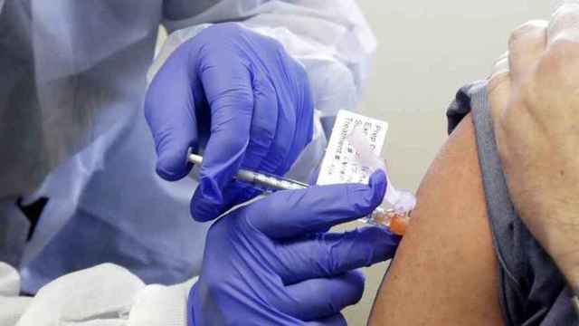 Un enfermero vacunando a una persona.