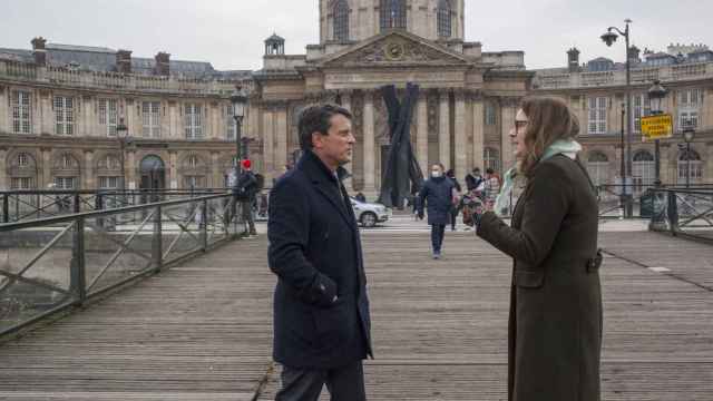 El ex primer ministro francés, Manuel Valls, en el Pont des Arts de París, habla con una mujer que le ha parado en la calle.