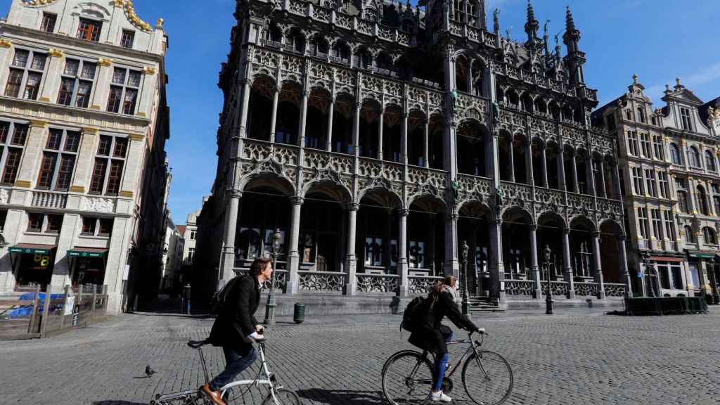 Dos ciclistas en la Grand Place de Bruselas (Bélgica).
