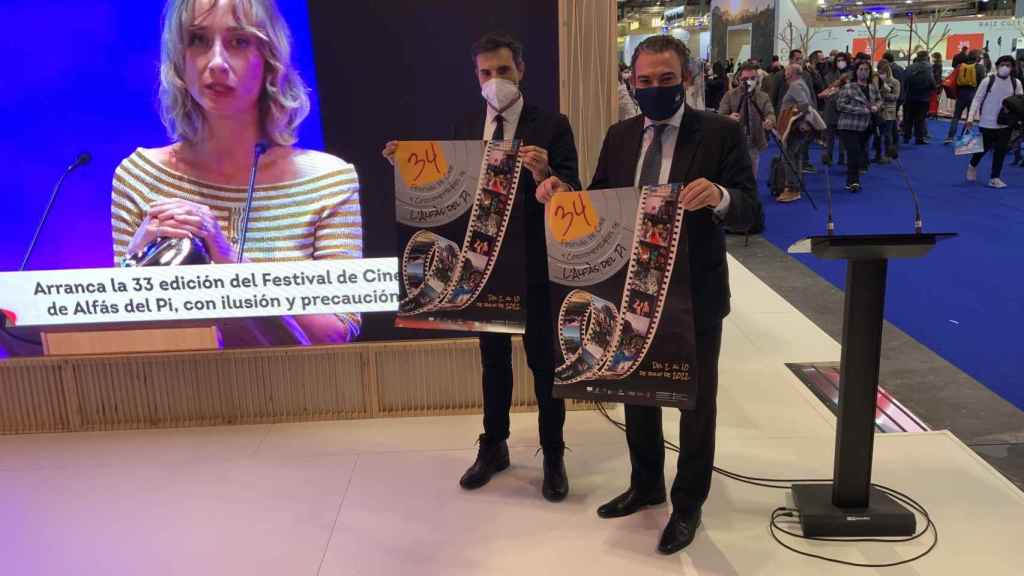 El alcalde de L'Alfàs y el director del Festival de Cine, con el cartel en el stand de Costa Blanca.