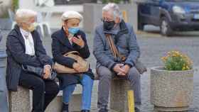Tres personas conversan en la calle
