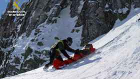 La Guardia Civil asegurando al montañero a la camilla de rescate