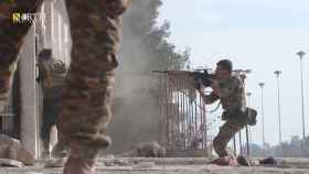 Un afiliado de las Fuerzas Democráticas Sirias apunta con un arma en el exterior de una prisión durante un enfrentamiento con los militantes del Estado Islámico en Hasaka, Siria.