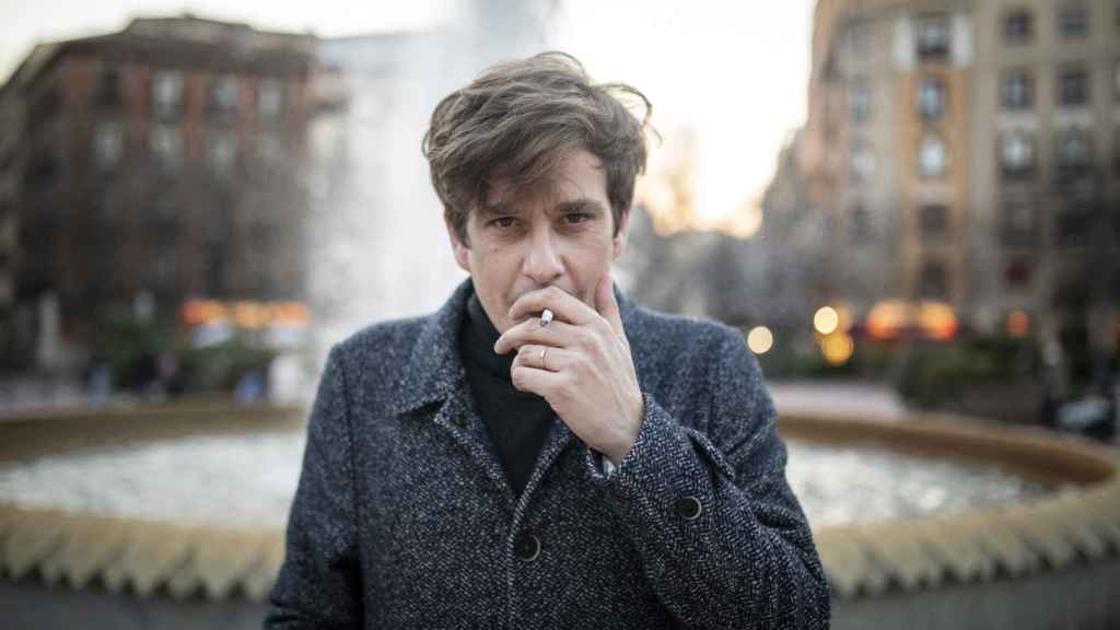 El escritor Alfonso J. Ussía en la plaza de Olavide fumándose un cigarro.