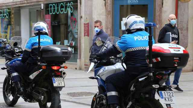 Policía local de Palencia conversa con un viandante por la calle Mayor