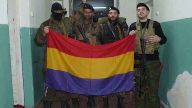 Los combatientes españoles (a cara descubierta y de izquierda a derecha) Sergio Becerra,  Ángel Arribas y Héctor Arroyo posan con una bandera republicana en el Este de Ucrania en 2014.
