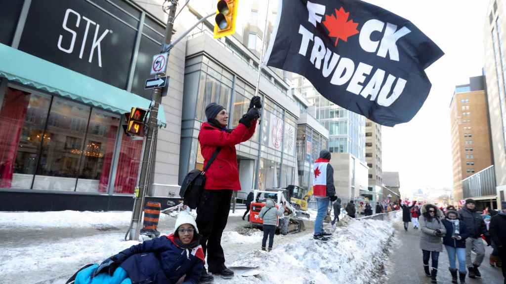 A protester holding a flag against President Justin Trudeau.
