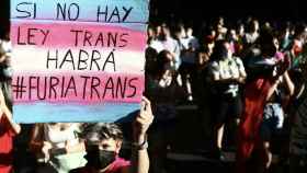 Una joven porta una pancarta en una manifestación a favor de la Ley Trans.