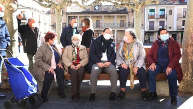 El presidente de Castilla y León, Alfonso Fernández Mañueco, con varios ancianos durante la campaña electoral.