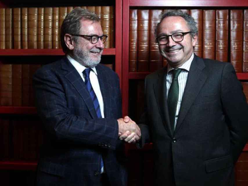 Manuel Polanco, a la derecha, estrecha la mano de Juan Luis Cebrián.