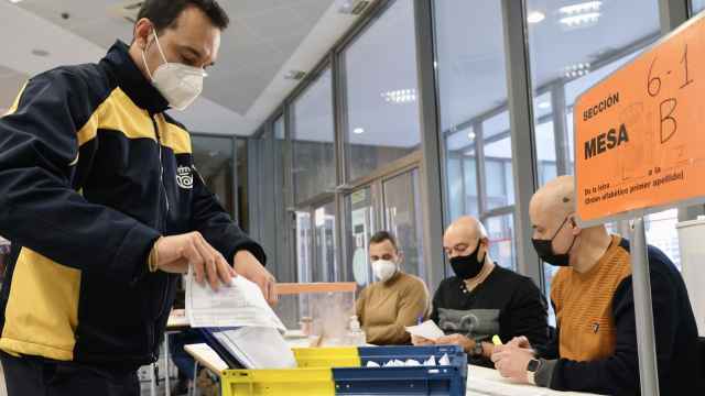 Un empleado entrega el voto por correo en una mesa electoral en las elecciones de Castilla y León.