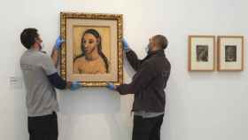 Los trabajadores del Museo Reina Sofía cuelgan 'Busto de mujer joven' de Picasso.