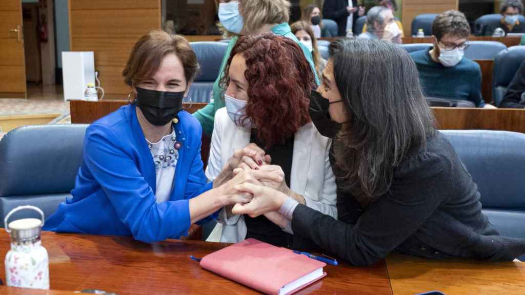La portavoz de Más Madrid, Mónica García, y la diputada María Pastor Valdés se dan la mano en un pleno de la Asamblea de Madrid.