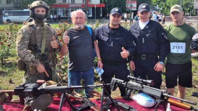Mario García, segundo por la izquierda, junto a soldados y rodeado de armas en Ucrania.
