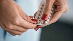 Una mujer sujeta un blíster de píldora anticonceptiva.