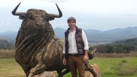 El empresaro Daniel Alcázar posando con la escultura de un toro en el año 2015.