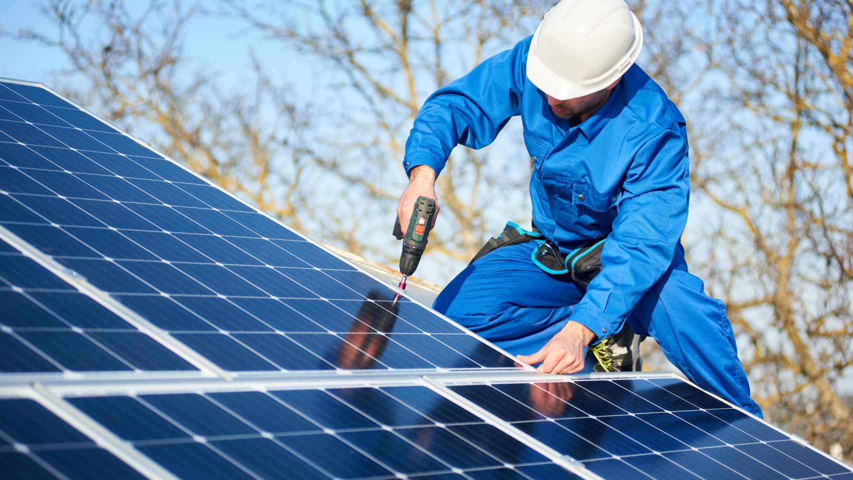 Un operario monta un panel solar en una casa