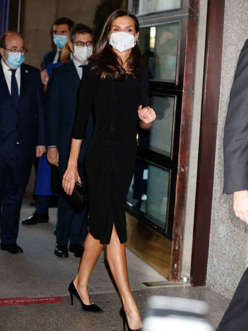 La reina Letizia con vestido negro de Armani y zapatos y cartera de mano a juego.